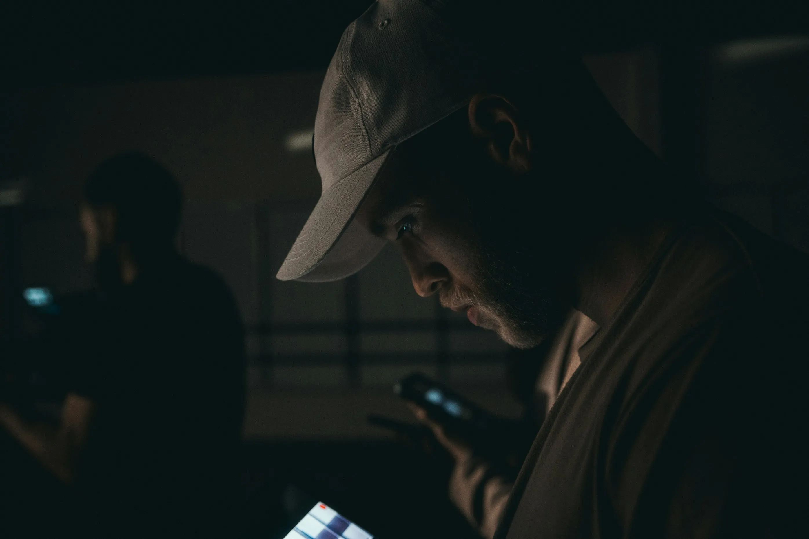 鏡やスマートフォンの写真を静かに確認する男性